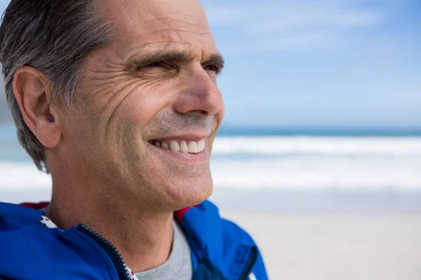 Uomo sorridente sulla spiaggia — Foto Stock