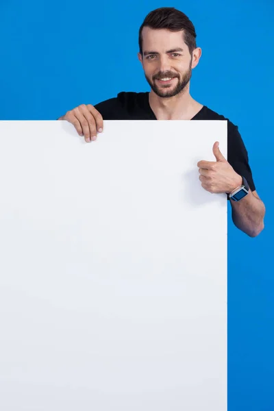 Hombre guapo sosteniendo un cartel en blanco —  Fotos de Stock