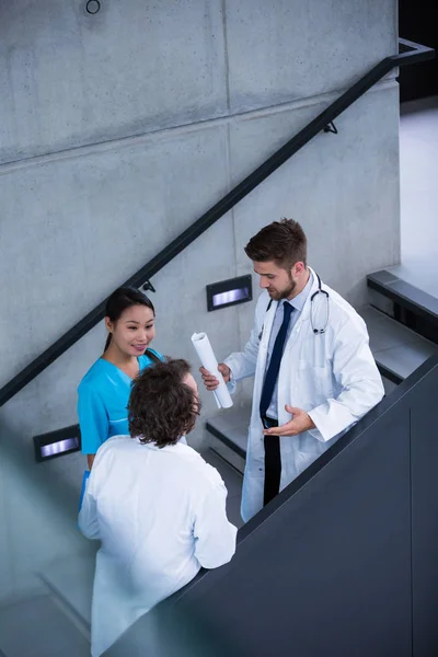 Médicos y enfermeras discutiendo sobre escaleras —  Fotos de Stock