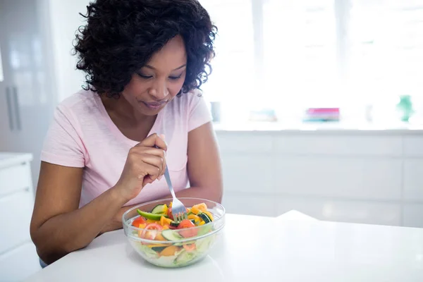 Mujer a dieta comiendo ensalada en la cocina —  Fotos de Stock