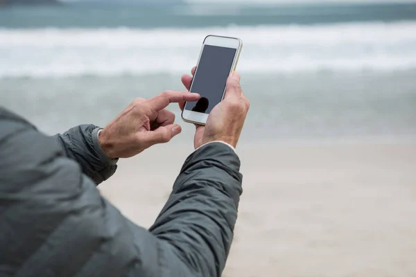 Muž pomocí mobilního telefonu na pláži — Stock fotografie