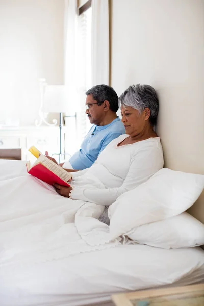 Pareja mayor leyendo novela — Foto de Stock