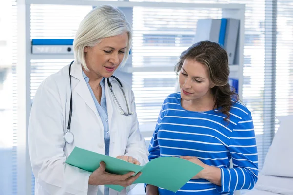 Médico mostrando informe médico a la mujer embarazada — Foto de Stock