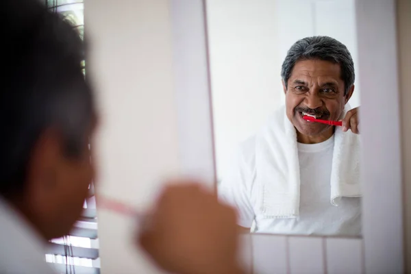 Uomo anziano lavarsi i denti in bagno — Foto Stock