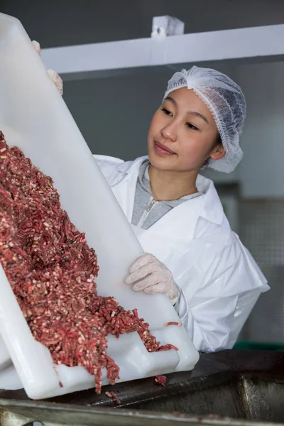 Butcher emptying tray with minced meat — Stock Photo, Image