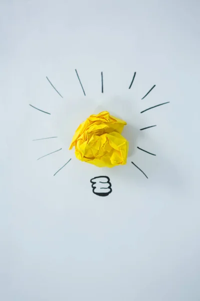 Light bulb getekend rond crumbled geel papier — Stockfoto