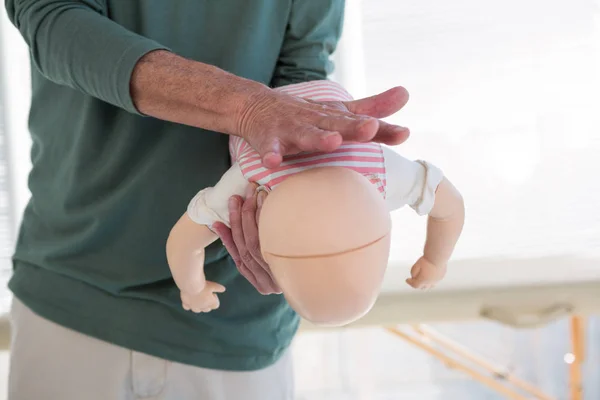 Paramedico che dimostra la rianimazione sul manichino per neonati — Foto Stock