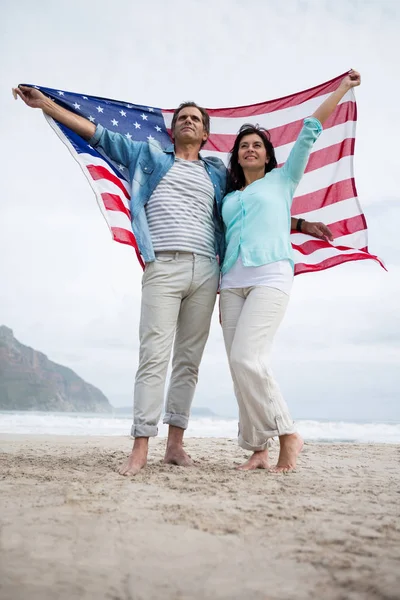夫妇在海滩上牵着美国国旗 — 图库照片