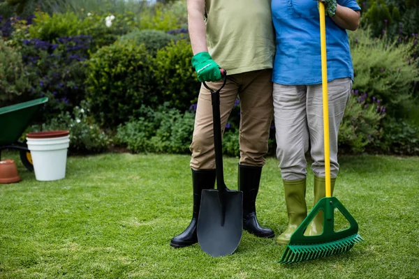 Seniorenpaar steht mit Gartengeräten — Stockfoto