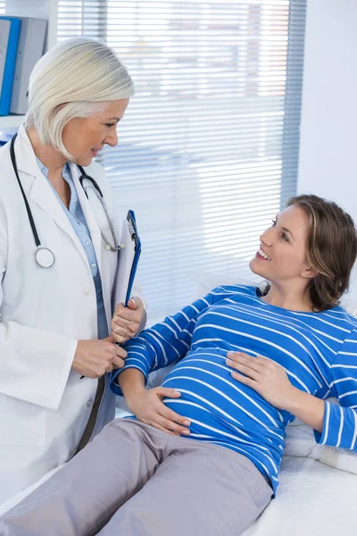 Беременная пациентка консультируется с врачом — стоковое фото