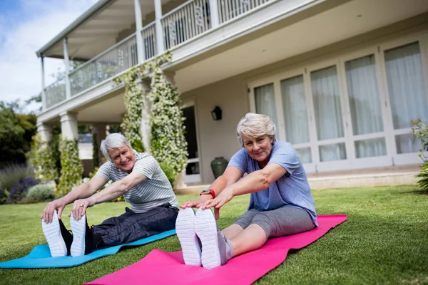 Coppia anziana che esegue esercizio di stretching — Foto Stock