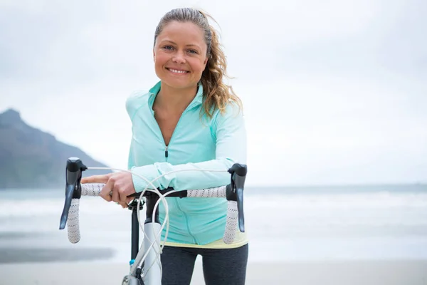 Vrouw met fiets op strand — Stockfoto