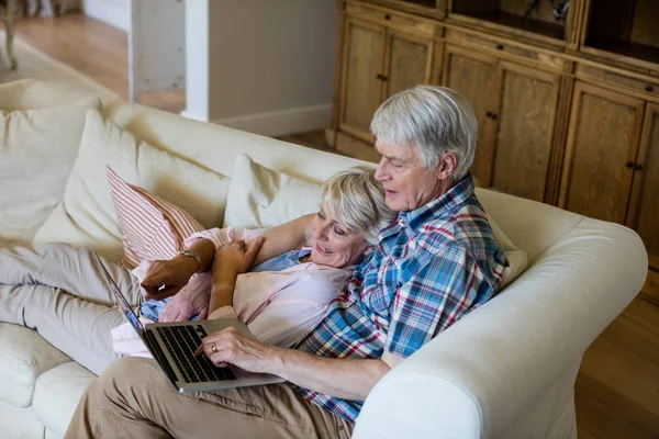 Senior paar met laptop in de woonkamer — Stockfoto