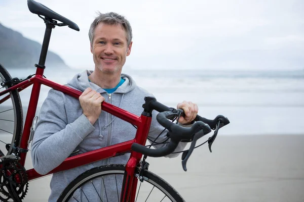 男子携带自行车上海滩 — 图库照片