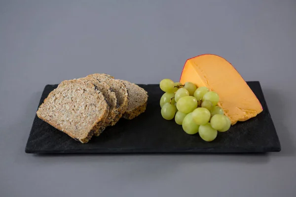 Queijo Gouda, uvas e fatias de pão — Fotografia de Stock