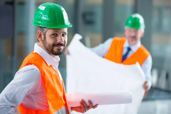 Arquitecto de pie de sombrero duro con plano —  Fotos de Stock