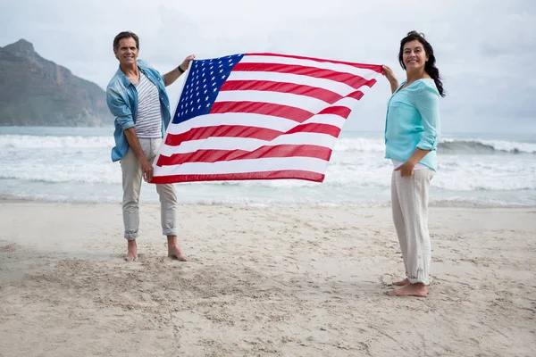Paar mit amerikanischer Flagge am Strand — Stockfoto