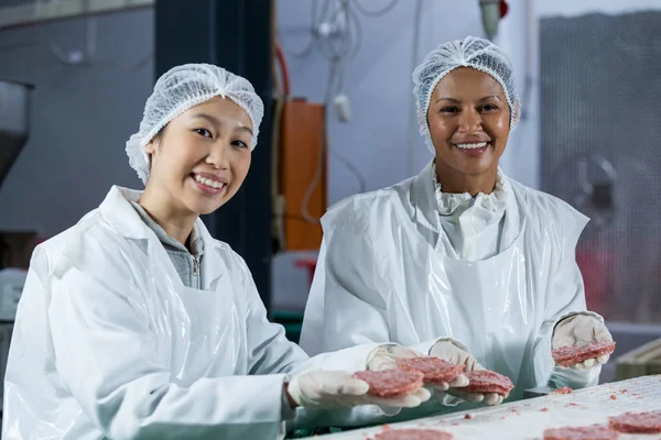 Carniceiros do sexo feminino processamento hambúrguer patty — Fotografia de Stock