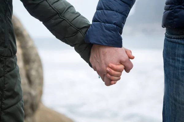 Coppia che si tiene per mano sulla spiaggia — Foto Stock