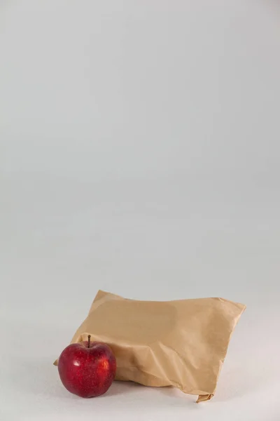Saco de almoço de papel marrom com maçã vermelha — Fotografia de Stock