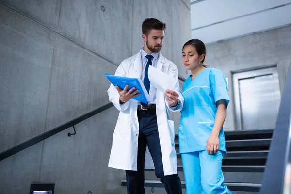 Läkare och sjuksköterska diskutera över betänkandet — Stockfoto