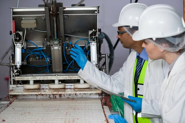 Technicians examining meat processing machine — Stock Photo, Image