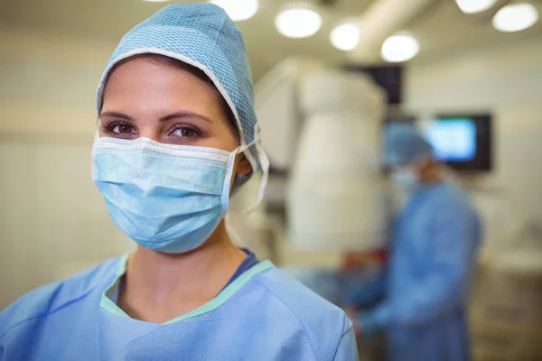 Portret van vrouwelijke chirurg dragen chirurgisch masker in werking theater — Stockfoto