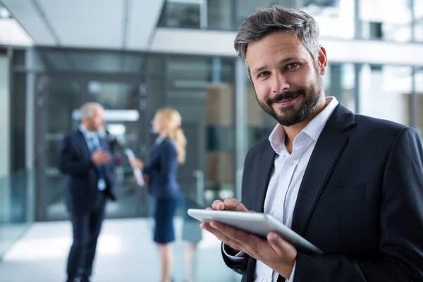 Businessman using tablet in office corridor — Stock Photo, Image