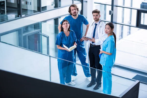 Cirujanos, médico y enfermero de pie en el hospital —  Fotos de Stock