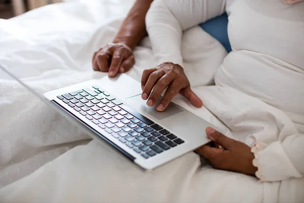 Paar met laptop in slaapkamer — Stockfoto