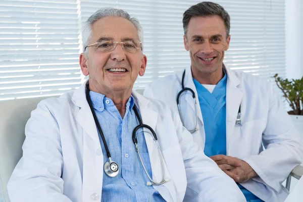Leende läkare sitter vid bord — Stockfoto