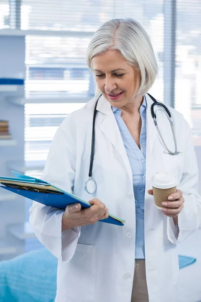 Médico segurando arquivo médico e café — Fotografia de Stock