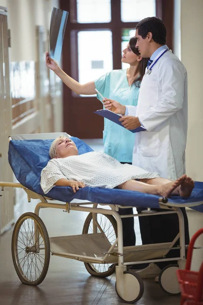 Médico y enfermera examinando informe en corredor — Foto de Stock