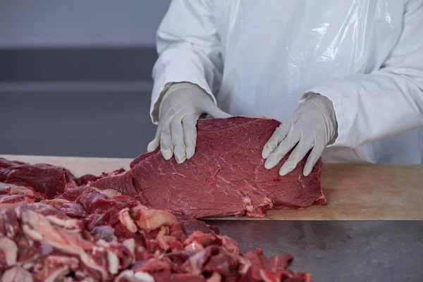 Tukang daging dengan daging mentah di atas meja — Stok Foto