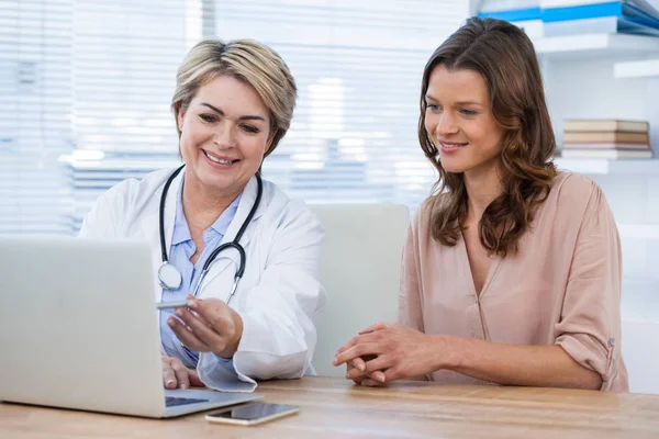 Doctor discutiendo con paciente sobre portátil — Foto de Stock