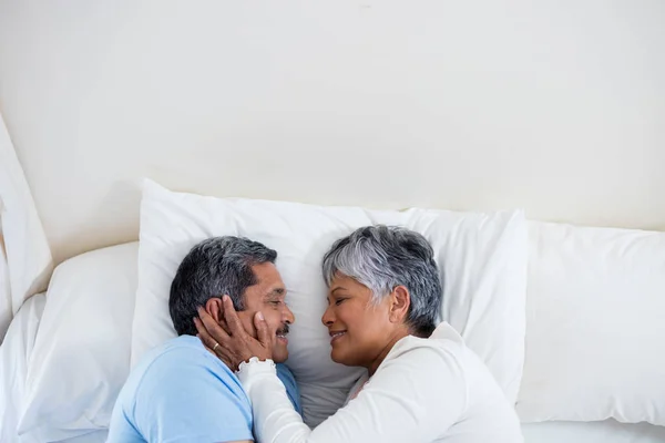 Äldre par avkopplande på sängen i sovrummet — Stockfoto