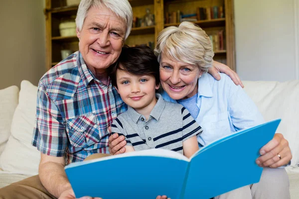 Grandparents and grandson holding book — Stock Photo, Image