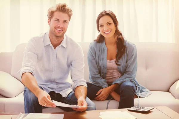 Par gör sina konton som satt i en soffa — Stockfoto