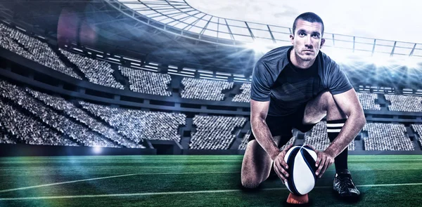 Jogador de rugby em camisa preta colocando bola — Fotografia de Stock