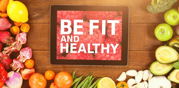 Tablet surrounded with fresh vegetables — Stock Photo, Image