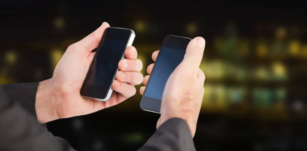 Biznesmen posiadania telefonu w każdej dłoni — Zdjęcie stockowe