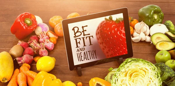 Tablet surrounded with fresh fruits and vegetable — Stock Photo, Image