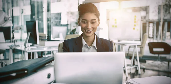 Smiling businesswoman by desk — Stock Photo, Image