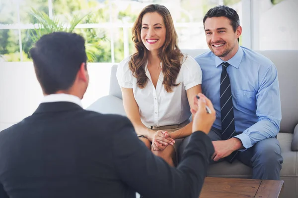Casal sorridente em reunião com um consultor financeiro — Fotografia de Stock