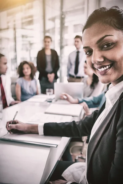 Affärskvinna skriva noter av kollegor i office — Stockfoto