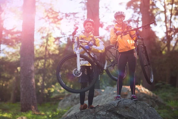 Biker casal transportando bicicleta de montanha — Fotografia de Stock