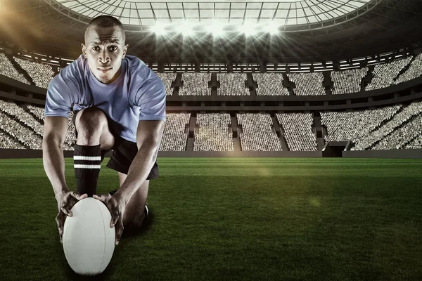 Rugbyspeler geknield en houden van de bal — Stockfoto