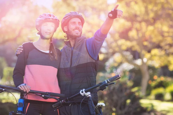 Pareja ciclista con bicicleta de montaña apuntando — Foto de Stock