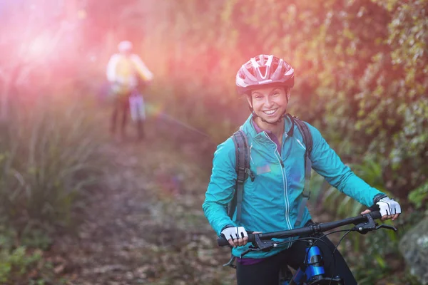 Kadın motorcu dağ bisikleti ile ayakta — Stok fotoğraf
