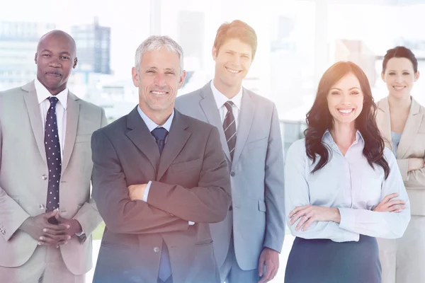 Equipe de negócios em pé na frente de uma janela brilhante — Fotografia de Stock